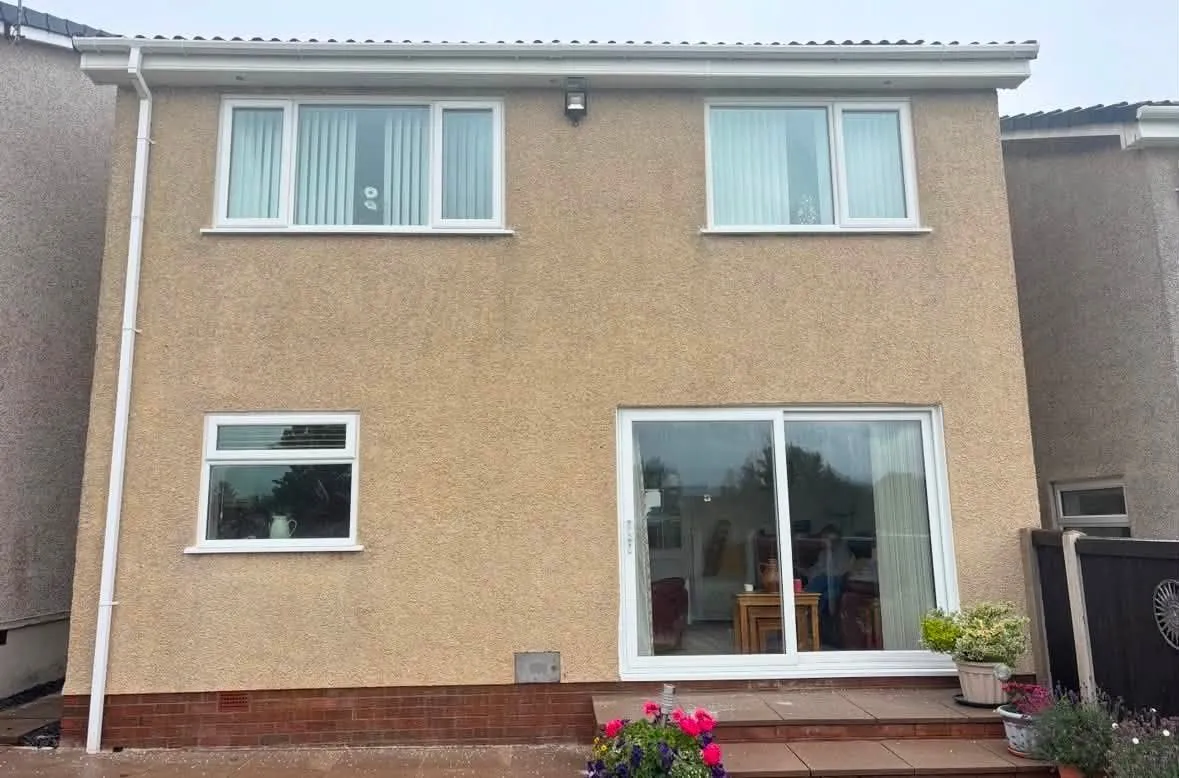 The same house after soft washing, render restored to a clean buff colour