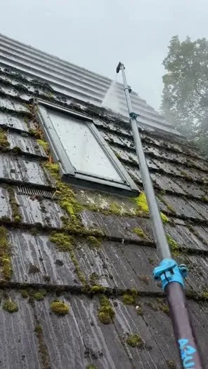 Soft washing moss from a tiled roof with a long pole